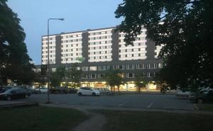 a large building with cars parked in a parking lot at Hotel Amado in Pori