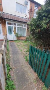 a green fence in front of a house at Spacious 2 Bedroom Home in Birmingham in Birmingham