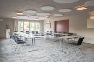 Hotel Vorfelder في فالدورف: قاعة اجتماعات مع طاولات وكراسي في مبنى