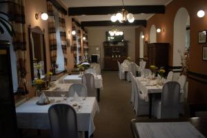 un comedor con mesas blancas y sillas blancas en Hotel U Kaple, en Děčín