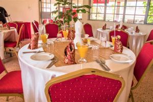 uma mesa num restaurante com uma toalha de mesa branca em Lake Bogoria Spa Kabarak em Nakuru