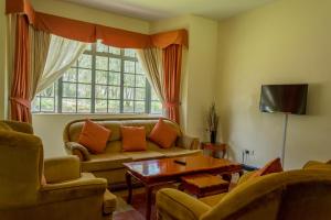 ein Wohnzimmer mit einem Sofa und einem Fenster in der Unterkunft Lake Bogoria Spa Kabarak in Nakuru