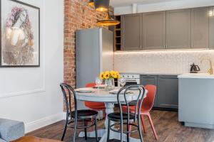 a kitchen with a table and chairs in a room at Imperial Apartments - Morski Art in Sopot