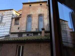 a tall brick building with a clock tower at Alla Scala 1746 in Siena