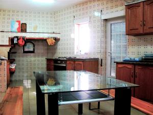 a kitchen with a glass table in the middle of it at Alojamento Turistico in Maceira +2 photos