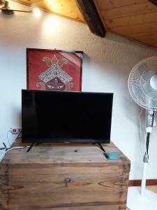 a flat screen tv on a wooden chest with a fan at Mansarda Meditazione e Yoga in Ossana