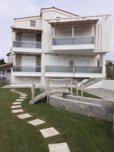 a white house with a walkway in front of it at Villa K View Nikiti in Nikiti