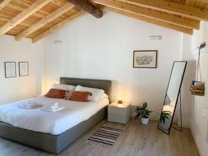Un dormitorio con una cama grande en una habitación con techos de madera. en Residenza Giulio Romano en Mantova
