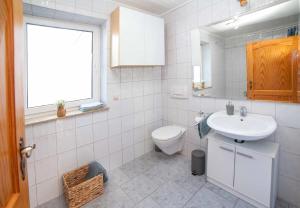 a white bathroom with a sink and a toilet at Ferienwohnung Haas in Lauda-Königshofen