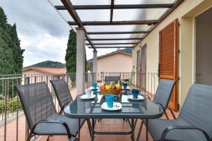 a table with chairs and a bowl of fruit on a balcony at Casa Lydia in Rio nellʼElba