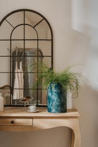 une table avec un vase avec une plante sur elle dans l'établissement Palazzo Natoli Boutique Hotel, à Palerme