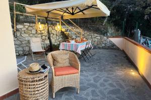 un patio con mesa, sillas y sombrilla en Casa Maja i Colombi - Goelba en Marciana