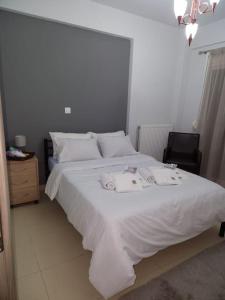 ein Schlafzimmer mit einem weißen Bett mit zwei Handtüchern darauf in der Unterkunft Sindos House SKG in Síndos