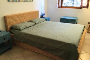 een bed in een kamer met twee blauwe tafels en een bed sidx sidx bij Casa Maja i Colombi - Goelba in Marciana