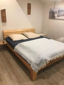 1 dormitorio con 1 cama grande con marco de madera en Les Agapanthes, en Noirmoutier-en-l'Île