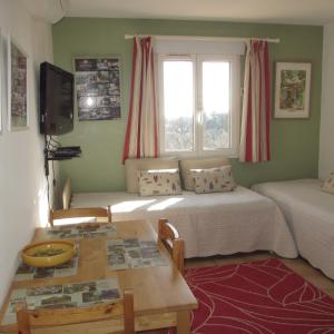 Habitación con 2 camas, mesa y ventana en Appartement les Balcons d'Azur, en Vernègues
