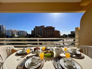 una mesa blanca con comida y bebidas en el balcón en Vilamoura Marina Mar 2 With Pool by Homing, en Vilamoura