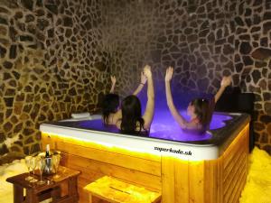 Tres chicas en un jacuzzi en una habitación en Apartmánový dom Fatrapark 1 s Wellness - Hlavná recepcia, en Ružomberok