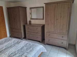 ein Schlafzimmer mit zwei Kommoden, einem Bett und einem Spiegel in der Unterkunft Ferienwohnung Susanne Würtenberger in Öhningen