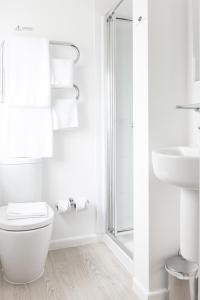 a white bathroom with a toilet and a shower at The Springfield Inn by Innkeeper's Collection in Lowdham