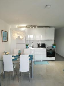 a kitchen with white cabinets and a table and chairs at Las Princesas in El Médano