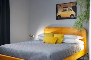 1 cama con almohadas amarillas y una foto de coche en Myway RDR Apartment, en Roma