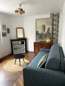 studio le 17 près de Paris في مونتلهيري: غرفة معيشة مع أريكة زرقاء وطاولة