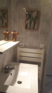 Baño blanco con lavabo y espejo en studio le 17 près de Paris, en Montlhéry