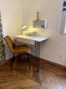 un escritorio con una silla y una lámpara. en studio le 17 près de Paris, en Montlhéry