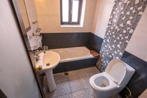 a bathroom with a toilet and a sink and a tub at Hotel Ganesh Himal in Kathmandu