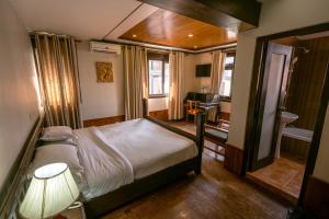 a bedroom with a bed with a lamp and a desk at Hotel Ganesh Himal in Kathmandu