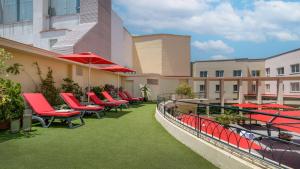 馬德里的住宿－馬德里科隆NH系列酒店，大楼内的阳台配有椅子和遮阳伞