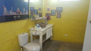 Baño amarillo con aseo y lavamanos en Casas La Colina, en Curití