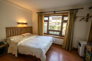 Un dormitorio con una cama grande y una ventana en Hotel Ganesh Himal, en Katmandú