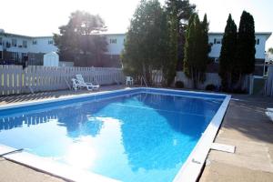 a large blue swimming pool with a white fence at Hotel Moncton in Moncton