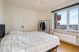 ein Schlafzimmer mit einem Bett und einem großen Fenster in der Unterkunft Fantastically located modern apartment with garage available in Ostende