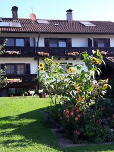 ein Haus mit einem Garten mit Blumen im Hof in der Unterkunft Landhaus Müller in Bad Birnbach