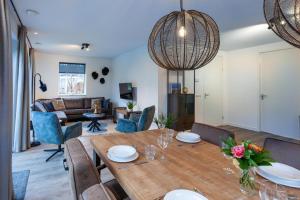 a dining room and living room with a table and chairs at Noordwijk Holiday Rentals in Noordwijk
