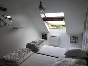 - une chambre avec 2 lits et une fenêtre dans l'établissement Duplex Normandie, tout confort Saint Valery en Caux, à Saint-Valery-en-Caux