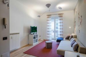 a living room with a couch and a tv at Easylife - Accogliente trilocale a Porta Romana relax e stile moderno nel cuore di Milano in Milan