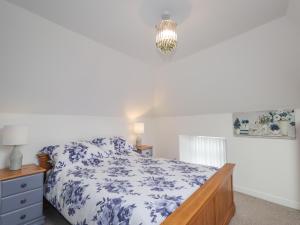 a bedroom with a bed with a blue and white comforter at Meredith Cottage in Banff