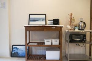 einen Schreibtisch mit Laptop neben einer Mikrowelle in der Unterkunft Sandy Home in Baler