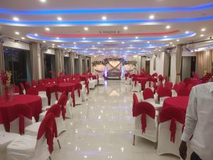 un salón de banquetes con mesas y sillas rojas y blancas en Lucky Beach Resort en Trincomalee