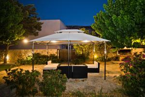 una gran sombrilla blanca en un jardín por la noche en Paloma Luxury Studios en Panormos Kalymnos