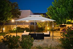 a large white umbrella in a garden at night at Paloma Luxury Studios in Panormos Kalymnos