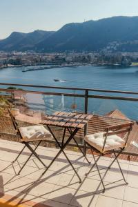 un tavolo e sedie su un balcone con vista sull'acqua di Window flat - The House Of Travelers a Como
