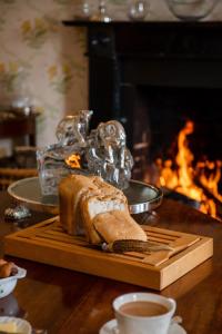 una hogaza de pan en una tabla de cortar junto a una chimenea en Ballymote Country House en Downpatrick