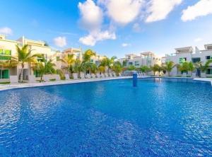 a large swimming pool in front of some buildings at Playa Palmera Beach Resort in Punta Cana