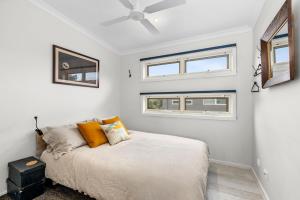 a bedroom with a bed and two windows at Alice's Palace, 2-minute walk to lifeguard patrolled surf beach in Ocean Grove