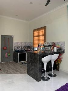 a room with a counter and a desk with two stools at Homestay Cikgu Fatiah in Kota Bharu